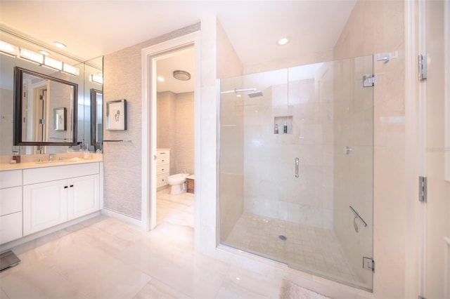 bathroom featuring vanity, toilet, and a shower with shower door