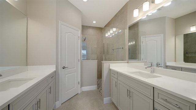 bathroom with vanity, a tile shower, and tile patterned flooring