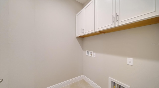 laundry area featuring washer hookup, cabinets, and light tile patterned floors