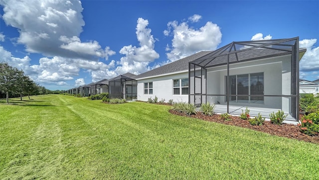 rear view of property with a lanai and a lawn