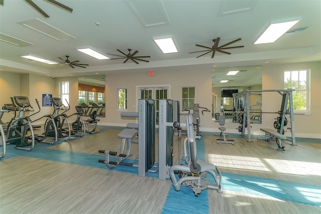 gym with wood-type flooring, a healthy amount of sunlight, and ceiling fan