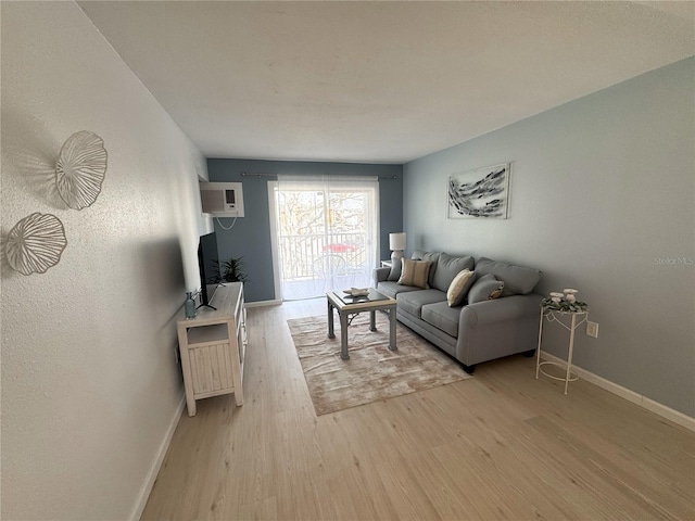 living area with light wood-type flooring and baseboards