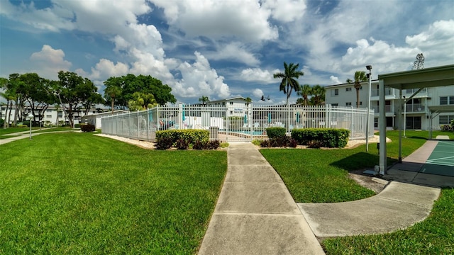 view of community featuring a residential view, fence, a pool, and a yard