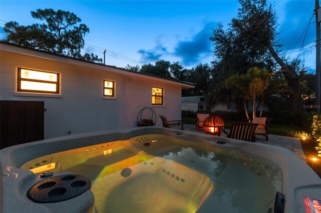 exterior space featuring a hot tub and an outdoor fire pit