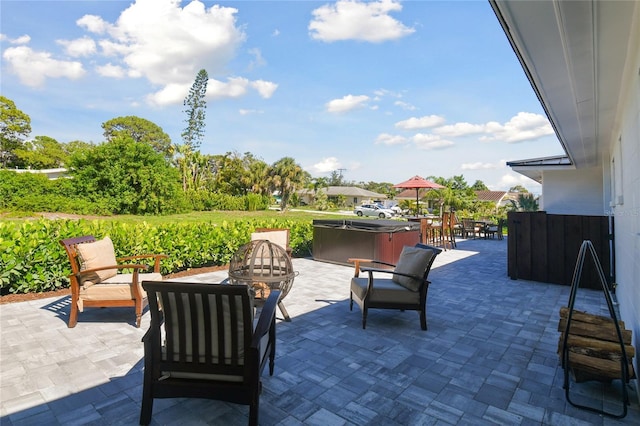 view of patio with a hot tub and a fire pit