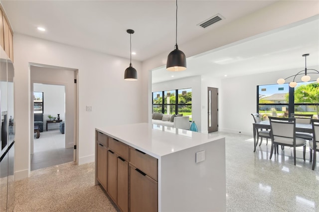 kitchen featuring an inviting chandelier, a kitchen island, and pendant lighting