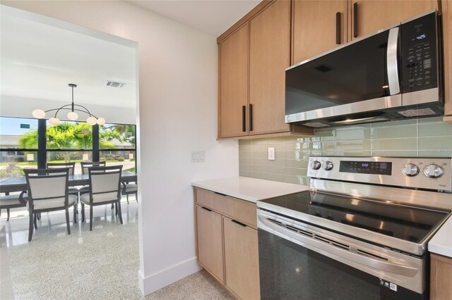 kitchen featuring decorative light fixtures, a chandelier, backsplash, and stainless steel appliances