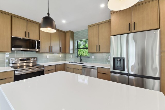 kitchen with stainless steel appliances, hanging light fixtures, sink, and tasteful backsplash