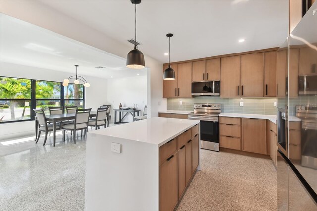 kitchen featuring stainless steel appliances, a kitchen island, hanging light fixtures, and backsplash