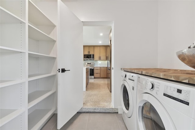 laundry area featuring light tile patterned flooring and washer and dryer