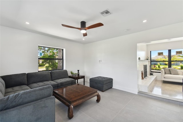 living room featuring ceiling fan and a fireplace