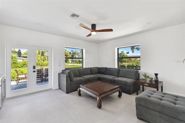 tiled living room with ceiling fan and french doors