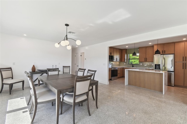 dining area featuring sink and an inviting chandelier