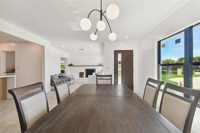 dining space with plenty of natural light, carpet floors, and a brick fireplace