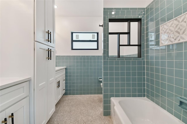 bathroom featuring vanity and tile walls