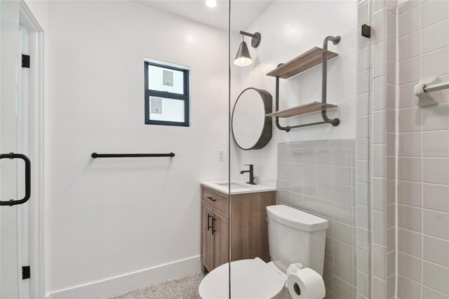 bathroom featuring vanity, toilet, and a shower with shower door