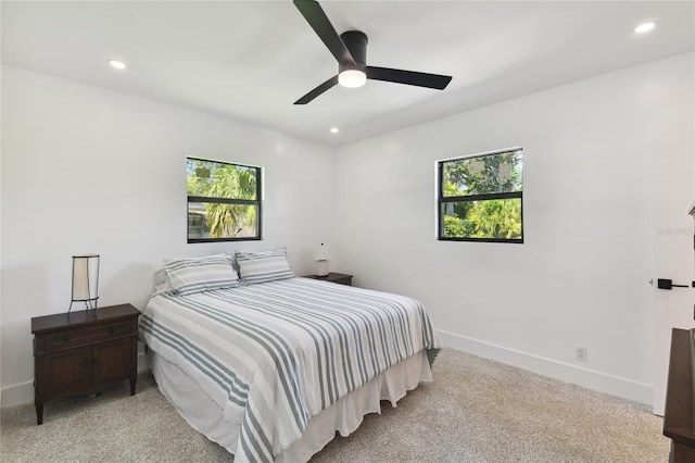 carpeted bedroom featuring multiple windows and ceiling fan