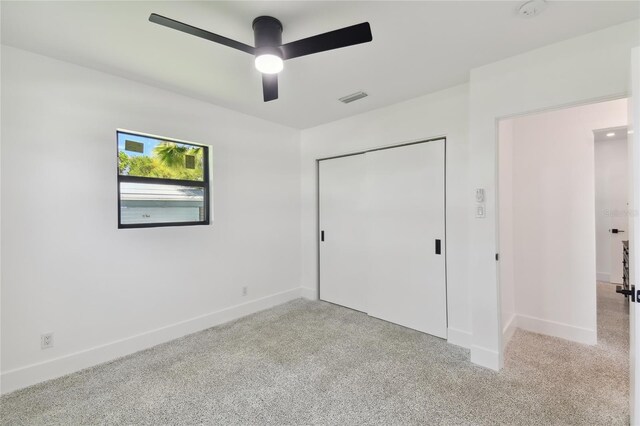 unfurnished bedroom with a closet, carpet floors, and ceiling fan