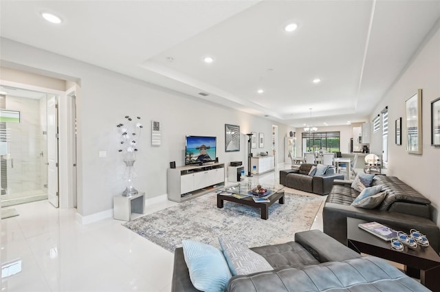 living room with an inviting chandelier and a raised ceiling