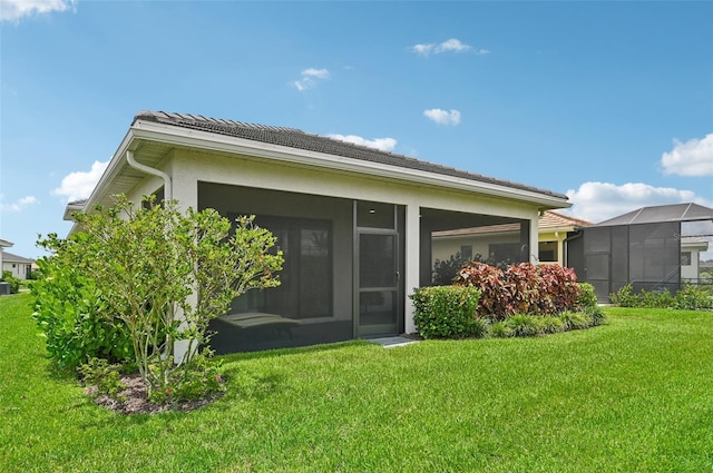 back of property featuring a yard and a sunroom