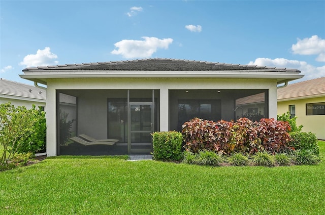 back of house featuring a sunroom and a yard