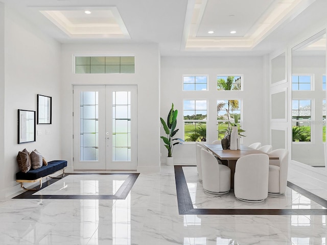 interior space featuring a raised ceiling, french doors, and a high ceiling