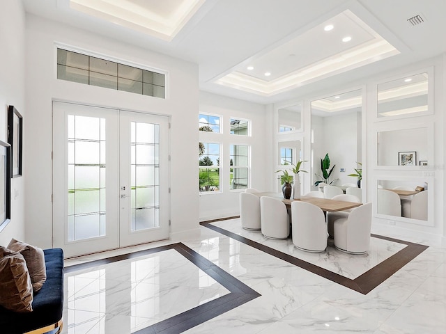 foyer entrance with french doors and a tray ceiling