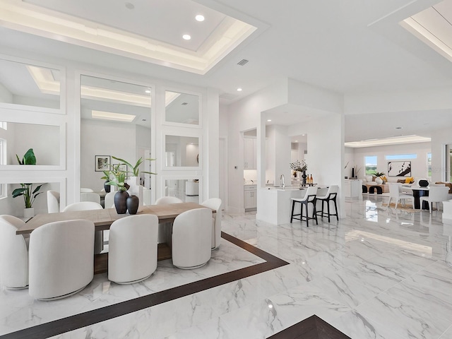 dining room featuring a raised ceiling and sink