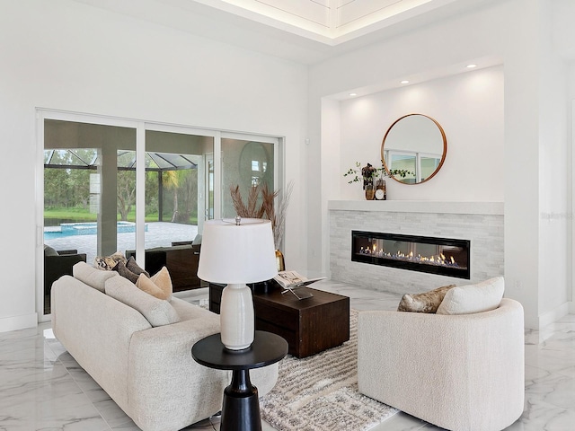 living room with a fireplace and a high ceiling