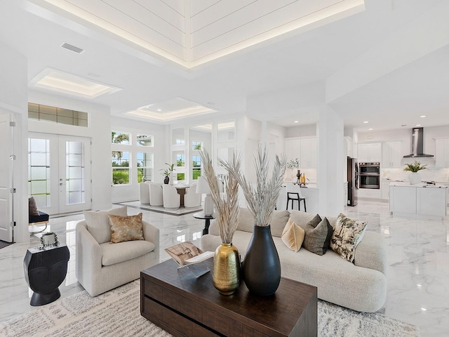 living room with a raised ceiling and french doors