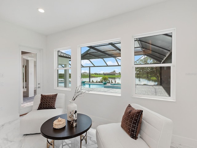 sitting room featuring a water view and vaulted ceiling