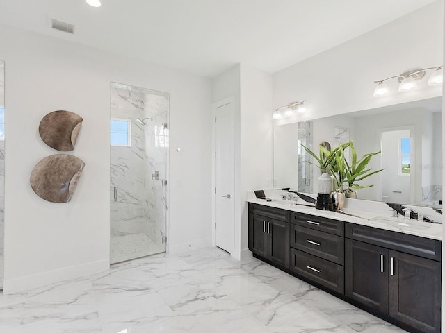 bathroom featuring a shower with door, vanity, and a healthy amount of sunlight