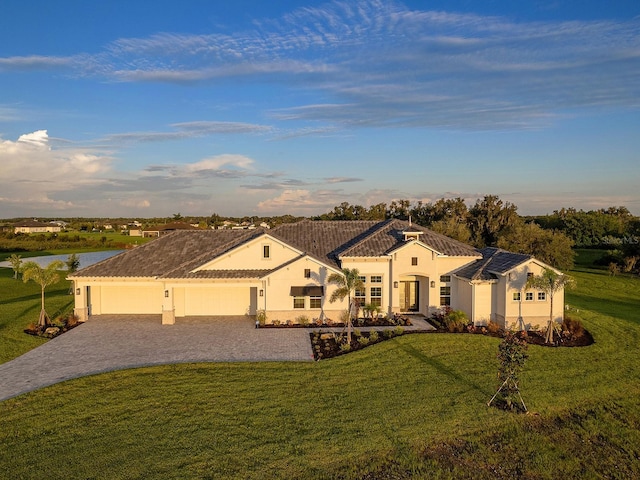 mediterranean / spanish-style house featuring a garage and a front lawn