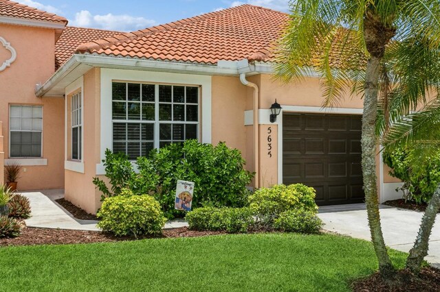 mediterranean / spanish-style house with a garage and a front lawn