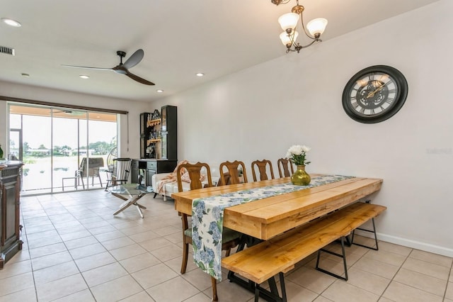 dining space featuring light tile patterned flooring and ceiling fan with notable chandelier