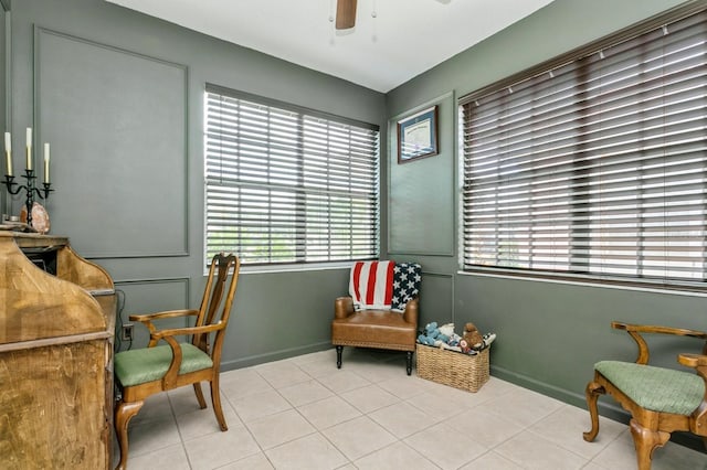 sitting room featuring light tile patterned floors and ceiling fan