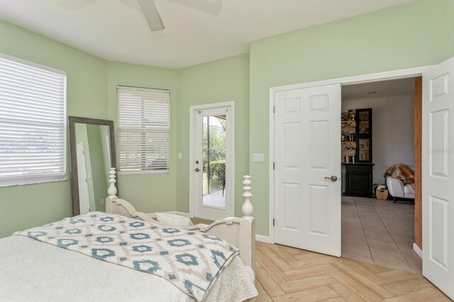 bedroom featuring access to exterior, ceiling fan, and light parquet flooring