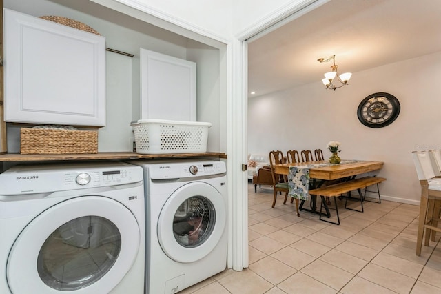 clothes washing area featuring an inviting chandelier, washer and dryer, and light tile patterned floors