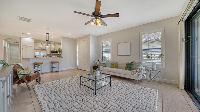 tiled living room with ceiling fan