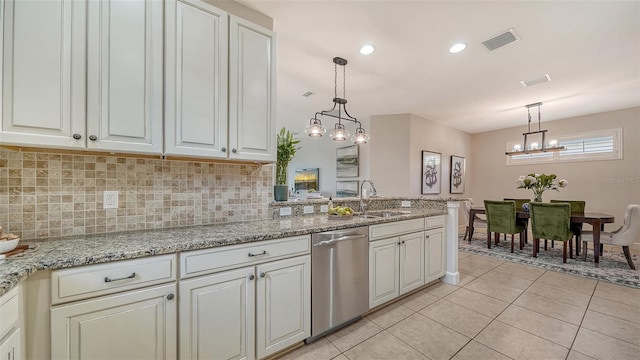 kitchen featuring light stone counters, stainless steel dishwasher, sink, pendant lighting, and light tile patterned floors