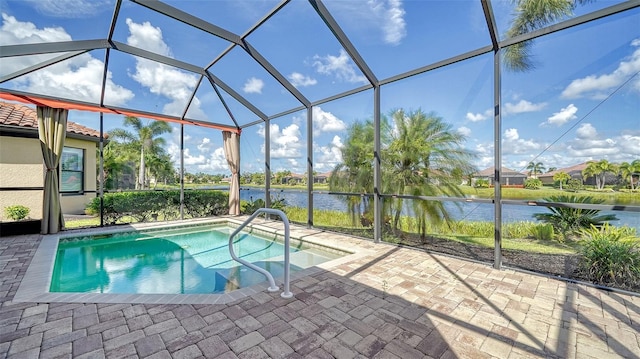 view of pool with a lanai, a patio area, and a water view