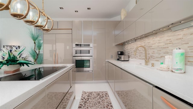 kitchen with pendant lighting, backsplash, sink, light tile patterned floors, and stainless steel appliances