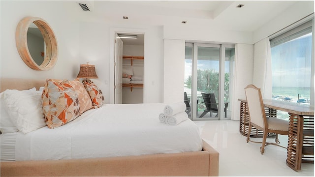 bedroom with access to exterior, a spacious closet, light tile patterned floors, and a closet