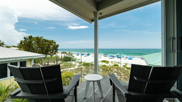 balcony featuring a view of the beach and a water view