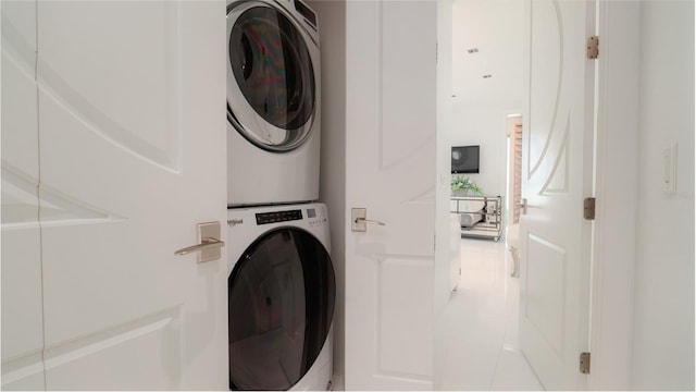 washroom featuring light tile patterned flooring and stacked washer and clothes dryer