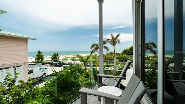 balcony featuring a water view and a view of the beach