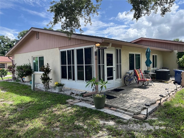 rear view of property featuring central AC, a patio area, and a yard