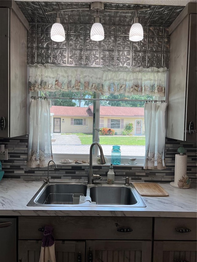 kitchen with sink, backsplash, dishwasher, and dark brown cabinets