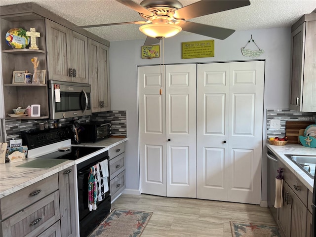 kitchen featuring ceiling fan, stainless steel appliances, and decorative backsplash