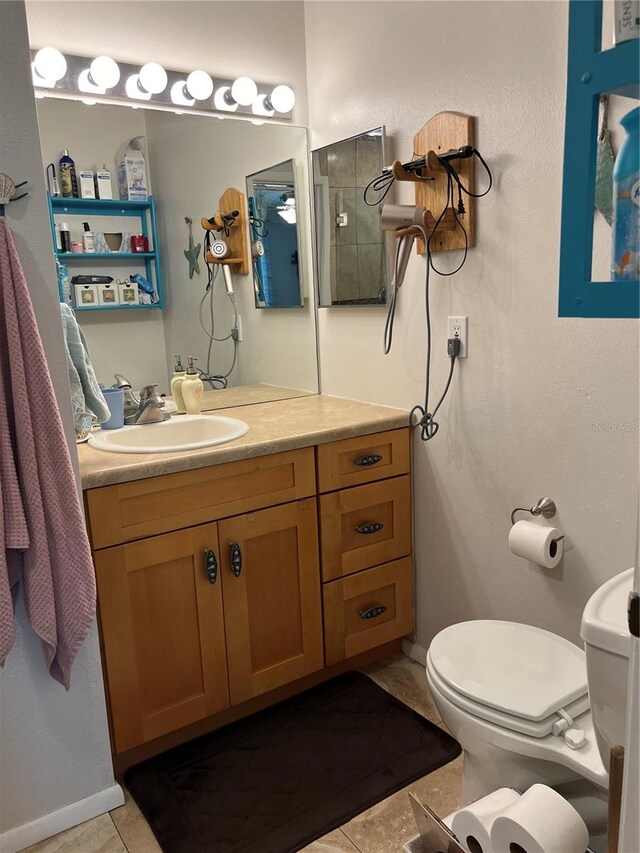 bathroom with toilet, tile patterned floors, and vanity